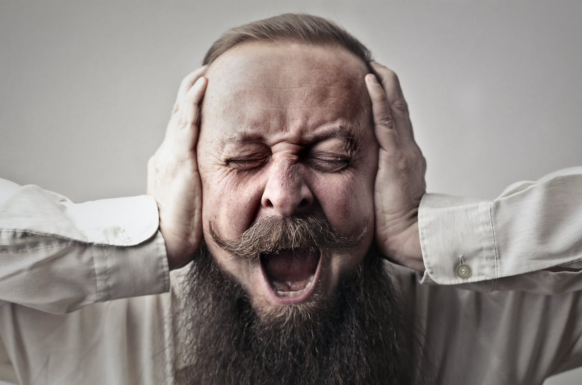 a man covering his ears due to excessive noise